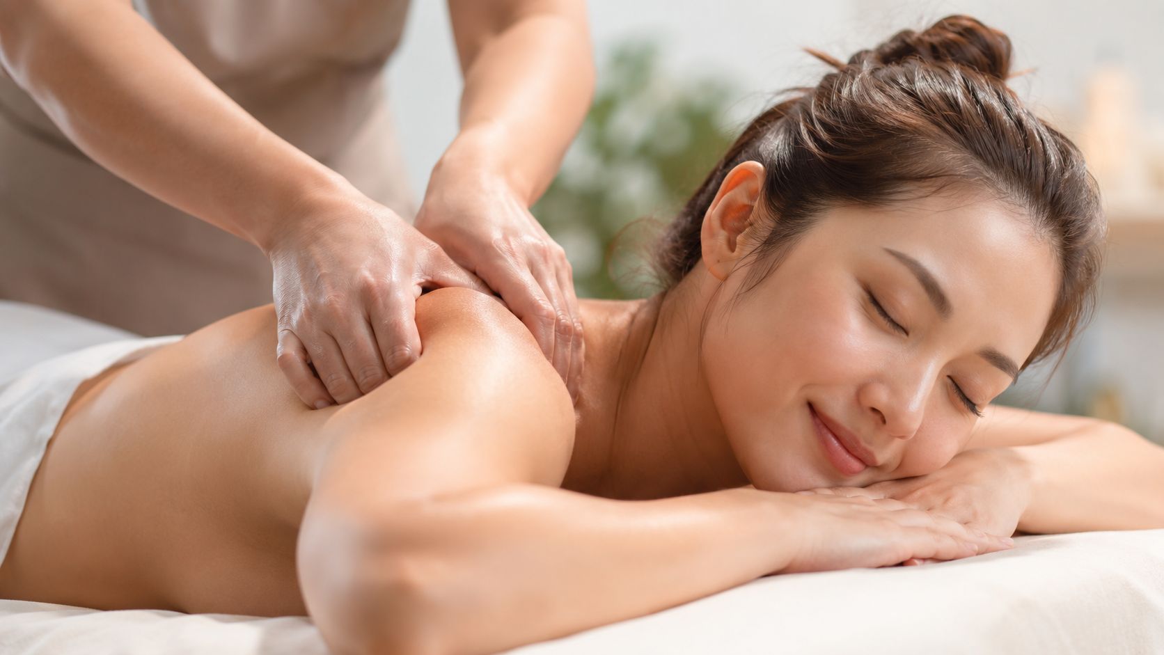 Une jeune femme détendue reçoit un massage relaxant des épaules dans un institut de bien-être professionnel.
