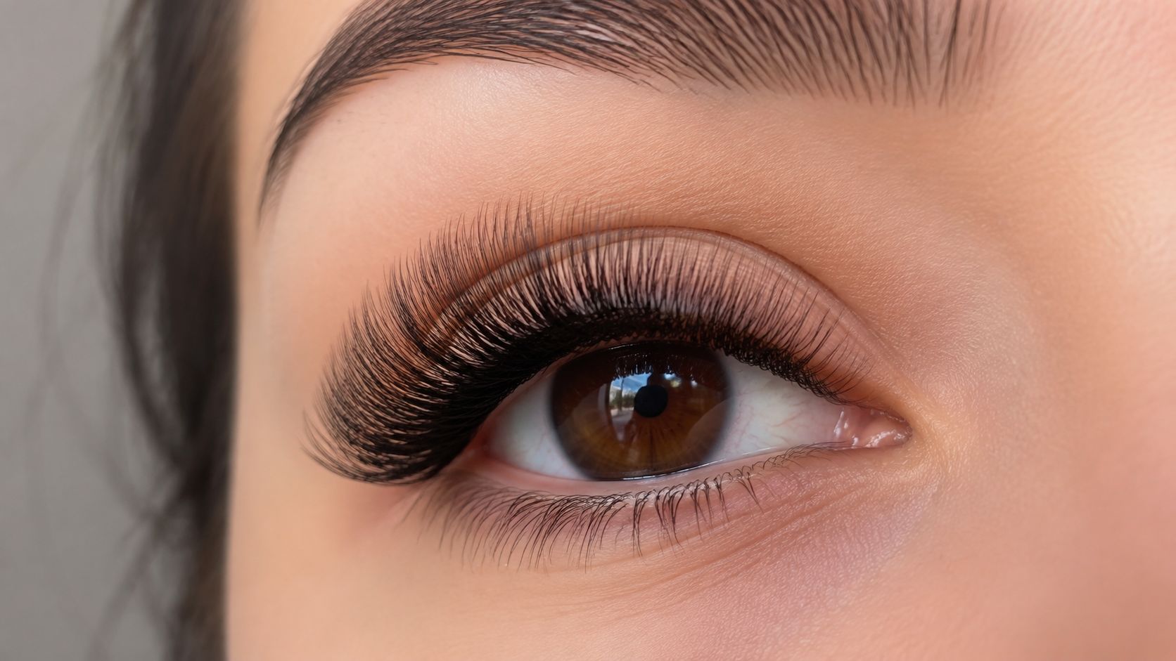 Gros plan sur un œil humain avec des extensions de cils fournies pour un regard intense et glamour.